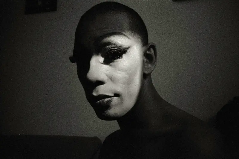 Portrait en noir et blanc d'une personne au crâne rasé, éclairé latéralement dans un style expressionniste dramatique