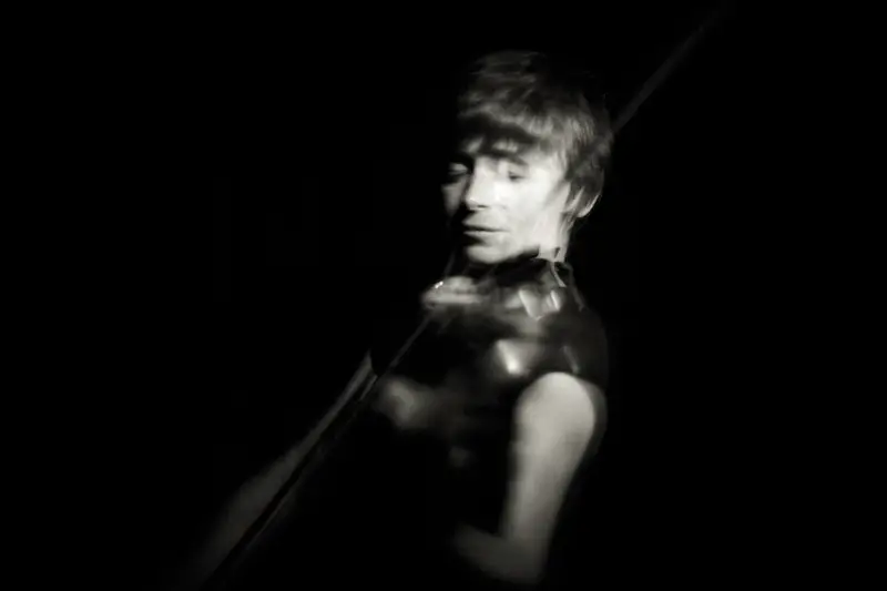 Portrait d'un chanteur en noir et blanc, éclairé latéralement dans un style chiaroscuro dramatique et granuleux