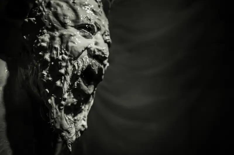 Portrait de profil d'un monstre visqueux éclairé par un chiaroscuro dramatique dans un style horreur expressionniste noir et blanc